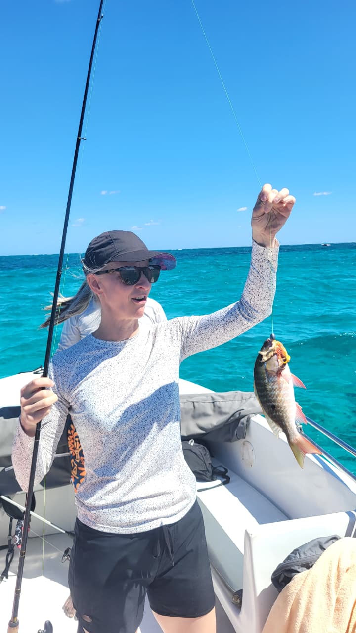 Catching fish on boat charter during Belize fishing and snorkeling tour